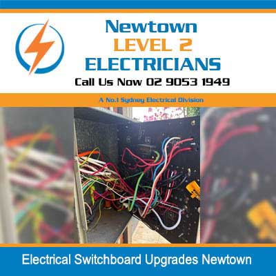 Level 2 electrician working on switchboard upgrades with colorful wiring and circuit breakers in Newtown